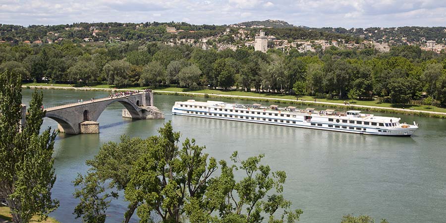A cruise boat travels past Pont d’Avignon on the Rhone river.